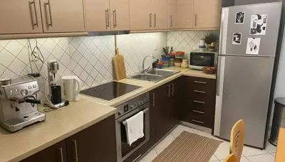 a small kitchen with a refrigerator and a sink at The Calm Corner of Ampelokipoi in Athens