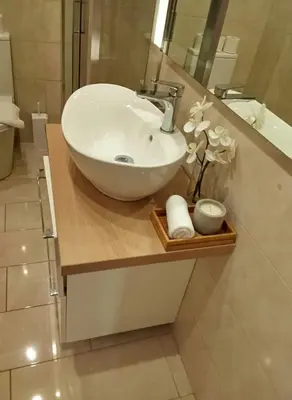 a bathroom with a white sink and a mirror at Coastal Comfort in the Heart of Faliro in Athens