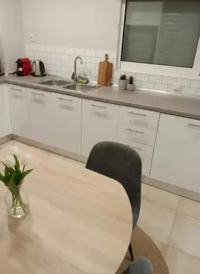 a kitchen with a table and a chair and a sink at Coastal Comfort in the Heart of Faliro in Athens