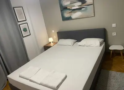 a bedroom with a white bed with two towels on it at Coastal Comfort in the Heart of Faliro in Athens