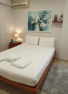 a bedroom with a large white bed in a room at Coastal Comfort in the Heart of Faliro in Athens