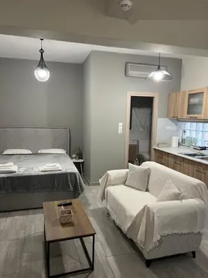 a bedroom with a bed and a couch and a table at Μοντέρνο στούντιο στη δάφνη in Athens