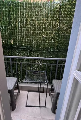 a balcony with two chairs and a green wall at Μοντέρνο στούντιο στη δάφνη in Athens