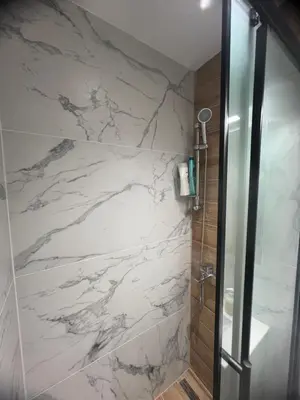 a bathroom with a shower with white marble at Μοντέρνο στούντιο στη δάφνη in Athens