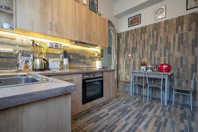 a kitchen with a sink and a table in it at Attiki Haven - 4BR Stay - Steps from Metro by ΜΡS in Athens