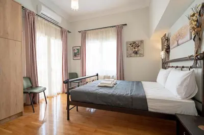 a bedroom with a bed and a large window at Attiki Haven - 4BR Stay - Steps from Metro by ΜΡS in Athens