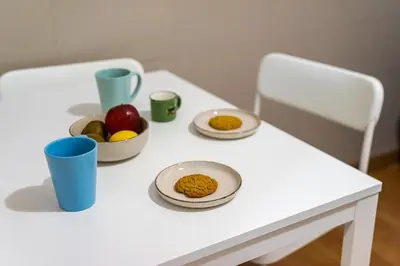 a white table with plates and bowls of fruit on it at Modern City Retreat in Kallithea in Athens