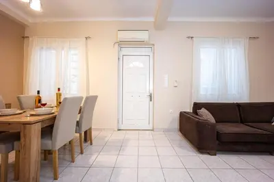 a living room with a table and a couch at Modern City Retreat in Kallithea in Athens