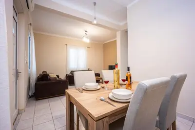 a dining table and chairs in a living room at Modern City Retreat in Kallithea in Athens