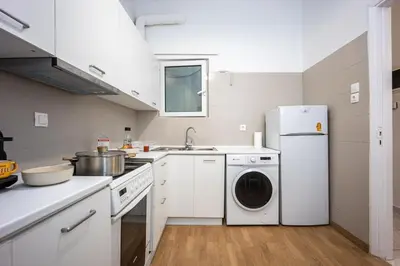 a kitchen with a white refrigerator and a dishwasher at Modern City Retreat in Kallithea in Athens