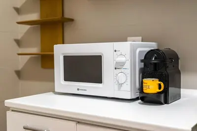 a white microwave sitting on top of a counter at Modern City Retreat in Kallithea in Athens