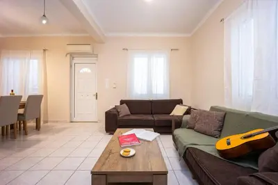 a living room with a couch and a guitar at Modern City Retreat in Kallithea in Athens