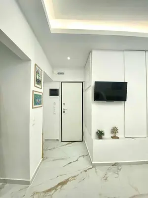 a hallway with white walls and a flat screen tv at Cozy 30sqm Studio in the Heart of Athens in Athens