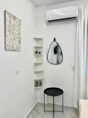 a room with a black chair and a mirror at Cozy 30sqm Studio in the Heart of Athens in Athens
