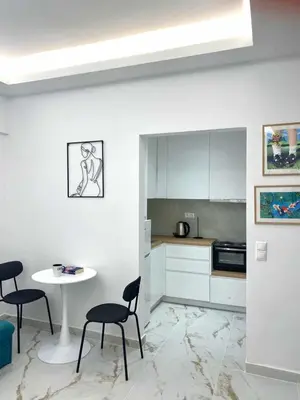 a kitchen with a table and two chairs and a table at Cozy 30sqm Studio in the Heart of Athens in Athens