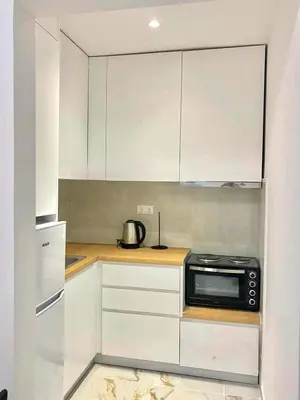 a kitchen with white cabinets and a black microwave at Cozy 30sqm Studio in the Heart of Athens in Athens