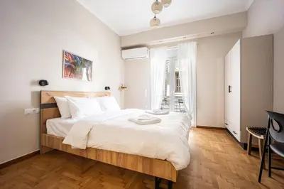a bedroom with a large bed with a wooden headboard at Athens #1 Experience in Athens