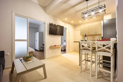 a kitchen and living room with a table and a dining room at Athens #1 Experience in Athens