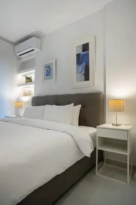 a bedroom with a large white bed and two lamps at Koukaki Urban Suites in Athens