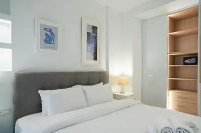 a bedroom with a large bed with white sheets at Koukaki Urban Suites in Athens