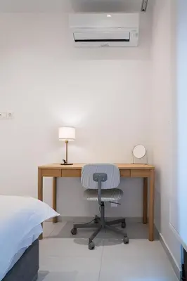 a desk with a chair and a lamp in a bedroom at Koukaki Urban Suites in Athens