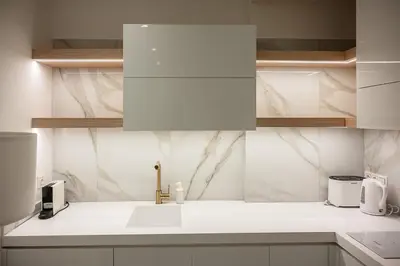 a kitchen with white marble walls and a sink at Koukaki Urban Suites in Athens