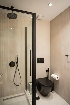 a bathroom with a black tub and a shower at Koukaki Urban Suites in Athens