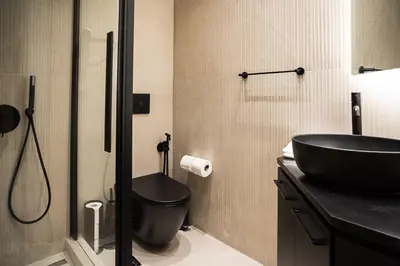 a bathroom with a black sink and a toilet at Koukaki Urban Suites in Athens