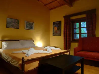 a bedroom with a bed and a red chair at The Wooden Nest, Cozy Private Room in Spáta