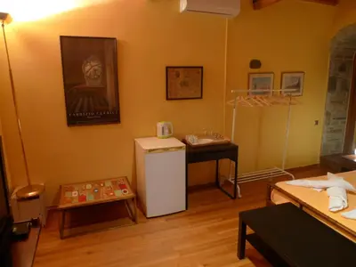 a living room with a refrigerator and a table at The Wooden Nest, Cozy Private Room in Spáta