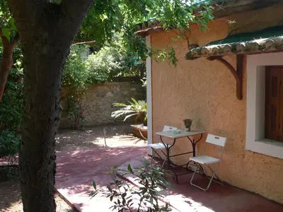 a table and chairs next to a building with a tree at The Wooden Nest, Cozy Private Room in Spáta