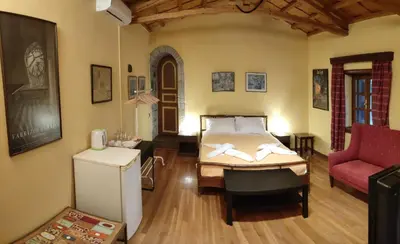 a bedroom with a bed and a red couch at The Wooden Nest, Cozy Private Room in Spáta