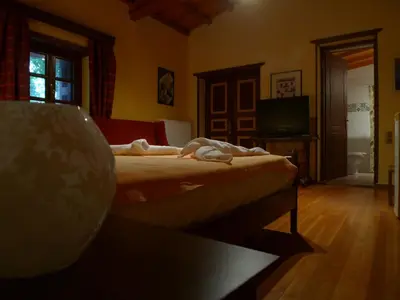 a bedroom with a bed and a tv in a room at The Wooden Nest, Cozy Private Room in Spáta