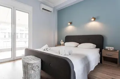 a bedroom with a large bed with a large window at Spacious 3br Apartment with Terrace in Exarchea in Athens