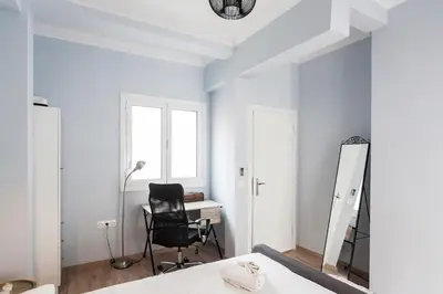 a bedroom with a bed and a desk and a chair at Spacious 3br Apartment with Terrace in Exarchea in Athens