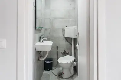 a small bathroom with a toilet and a sink at Spacious 3br Apartment with Terrace in Exarchea in Athens