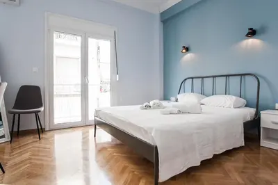 a bedroom with a large bed with blue walls at Spacious 3br Apartment with Terrace in Exarchea in Athens