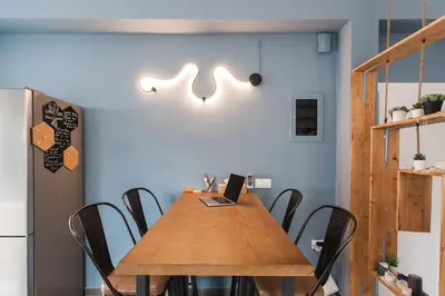 a dining room with a wooden table with a laptop on it at Spacious 3br Apartment with Terrace in Exarchea in Athens