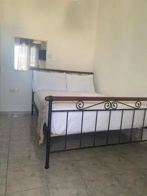 a bed with white sheets and pillows in a room at Penthouse in apartment building, in the Center in Athens