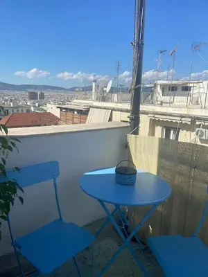 a blue table and two chairs on a balcony at Penthouse in apartment building, in the Center in Athens