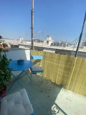a blue table and chair on a balcony with a view at Penthouse in apartment building, in the Center in Athens