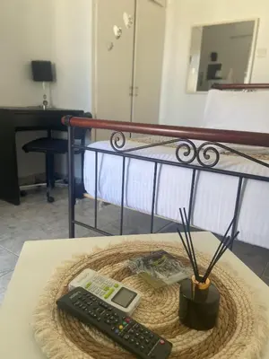 a remote control sitting on top of a table next to a bed at Penthouse in apartment building, in the Center in Athens