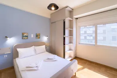 a small bedroom with a white bed and a window at Panormou Neon - Urban Apartment 3A in Athens