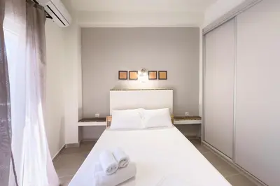 a bedroom with a white bed with towels on it at Panormou Neon - Urban Apartment 3A in Athens