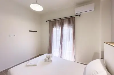 a room with a white bed with a window at Panormou Neon - Urban Apartment 3A in Athens