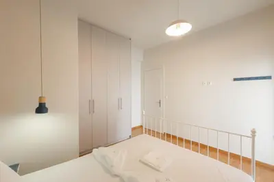 a bedroom with a bed and white cabinets at Panormou Neon - Urban Apartment 3B in Athens