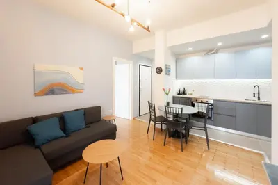 a living room and kitchen with a couch and a table at Panormou Neon - Urban Apartment 3B in Athens