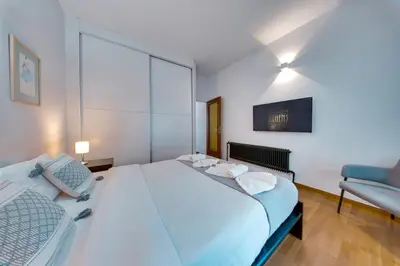 a bedroom with a large white bed and a couch at Stylish Flat between Syntagma Sq and Kolonaki in Athens