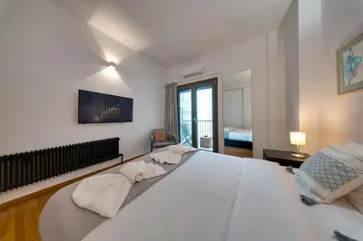 a bedroom with a large white bed and a window at Stylish Flat between Syntagma Sq and Kolonaki in Athens