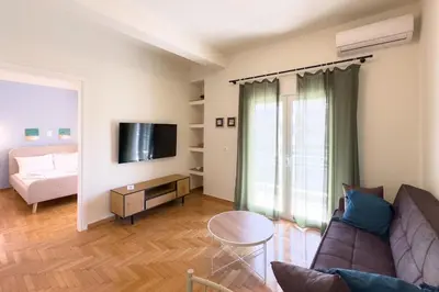 a living room with a couch and a tv at Panormou Neon - Urban Apartment 4A in Athens